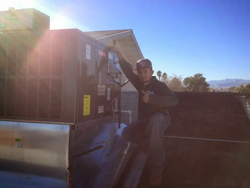 HVAC technician performing HVAC Inspection on a rooftop unit in Brewer